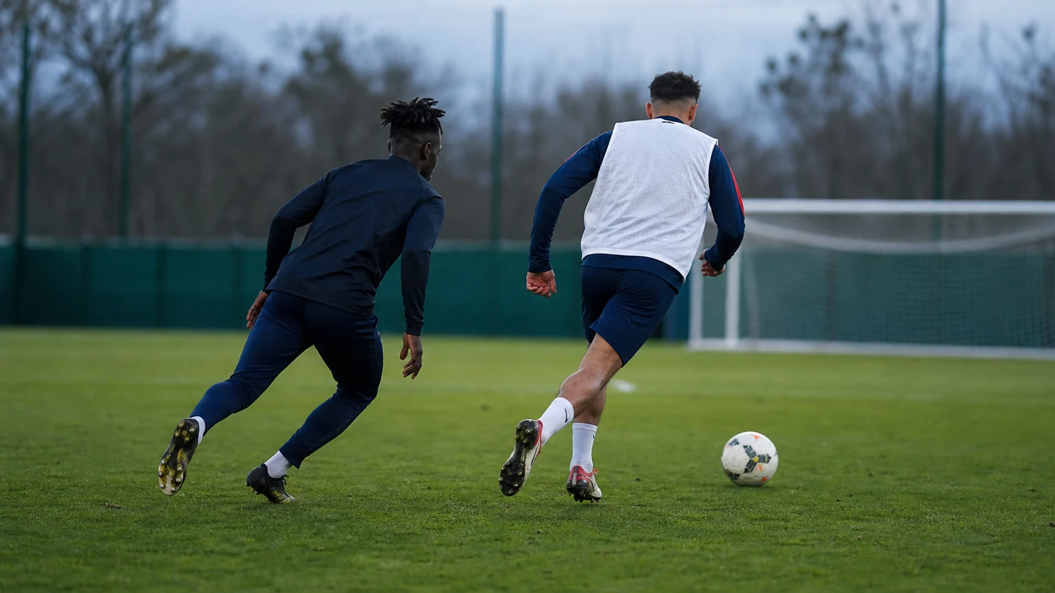 anonymous youth defender recovering diagonally to protect the middle after an attacker gains half a step, both players moving at...
